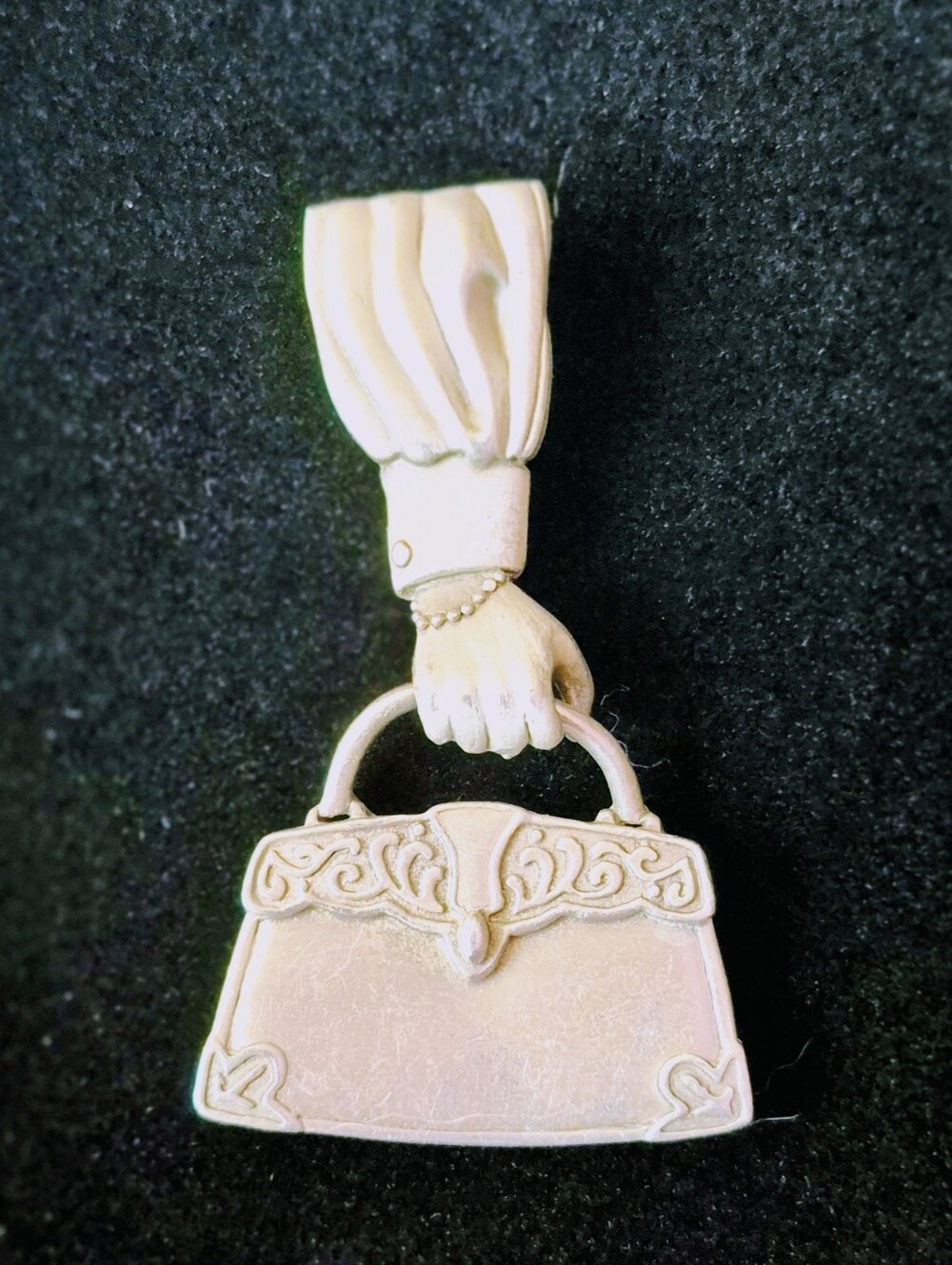 Vintage JJ (Jonette Jewelry) pewter brooch featuring a hand holding a Handbag